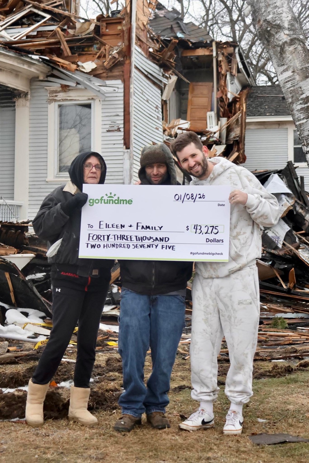 Josh Liljenquist with Eileen's family and a GoFundMe check after a house fire