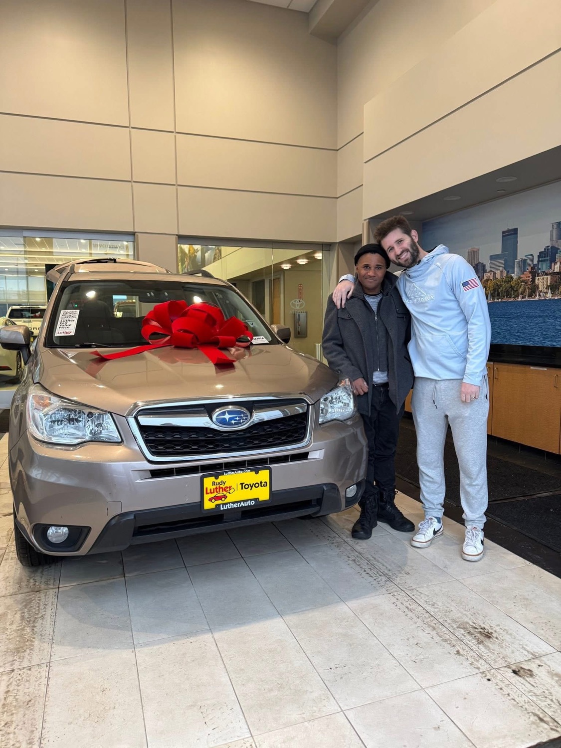 Josh Liljenquist with Xavier beside a vehicle with a bow