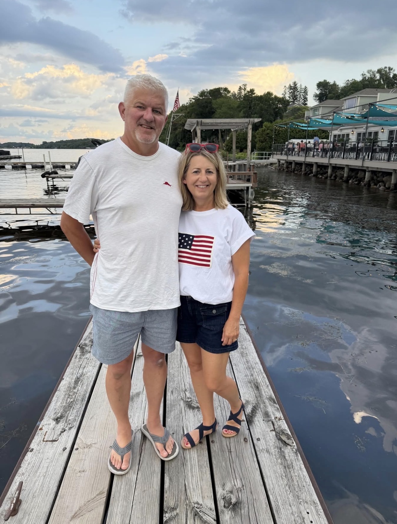 Josh’s parents standing together on a dock by a lake