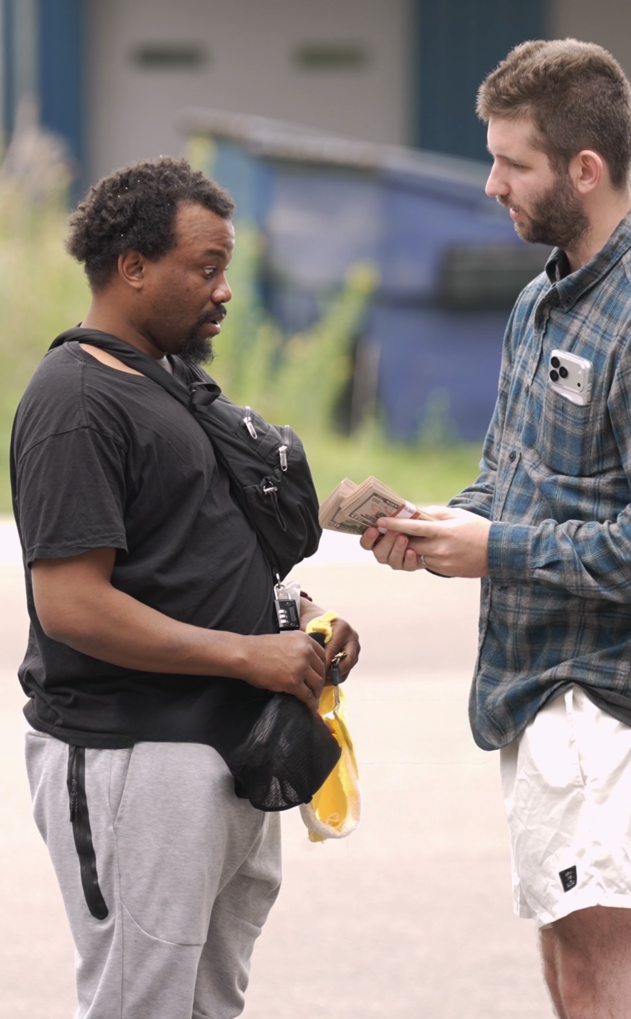Josh speaking with and offering practical assistance to a man outdoors