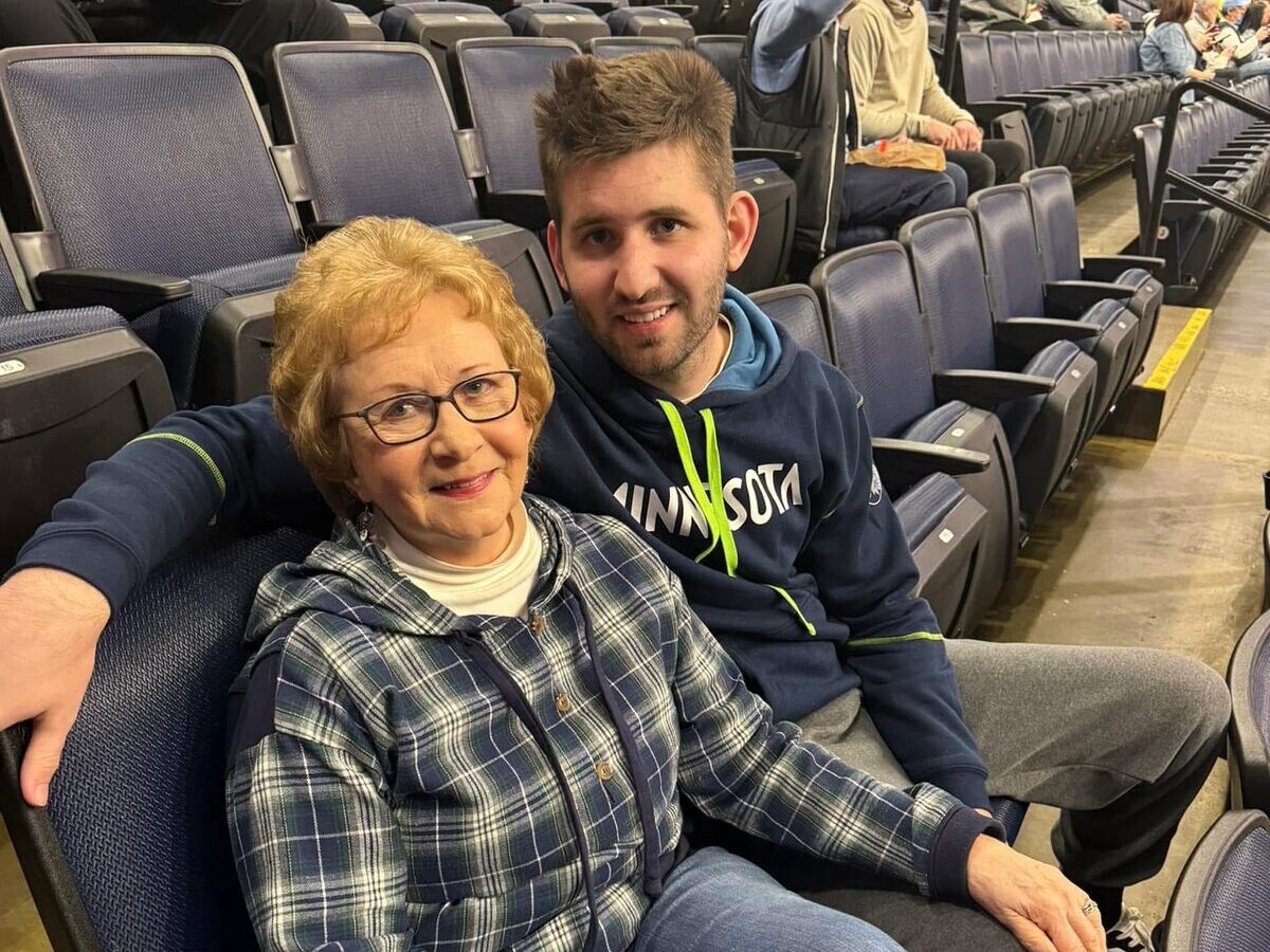 Josh Liljenquist sitting with his maternal grandmother, Mary Ann Westcott, at a sporting event.