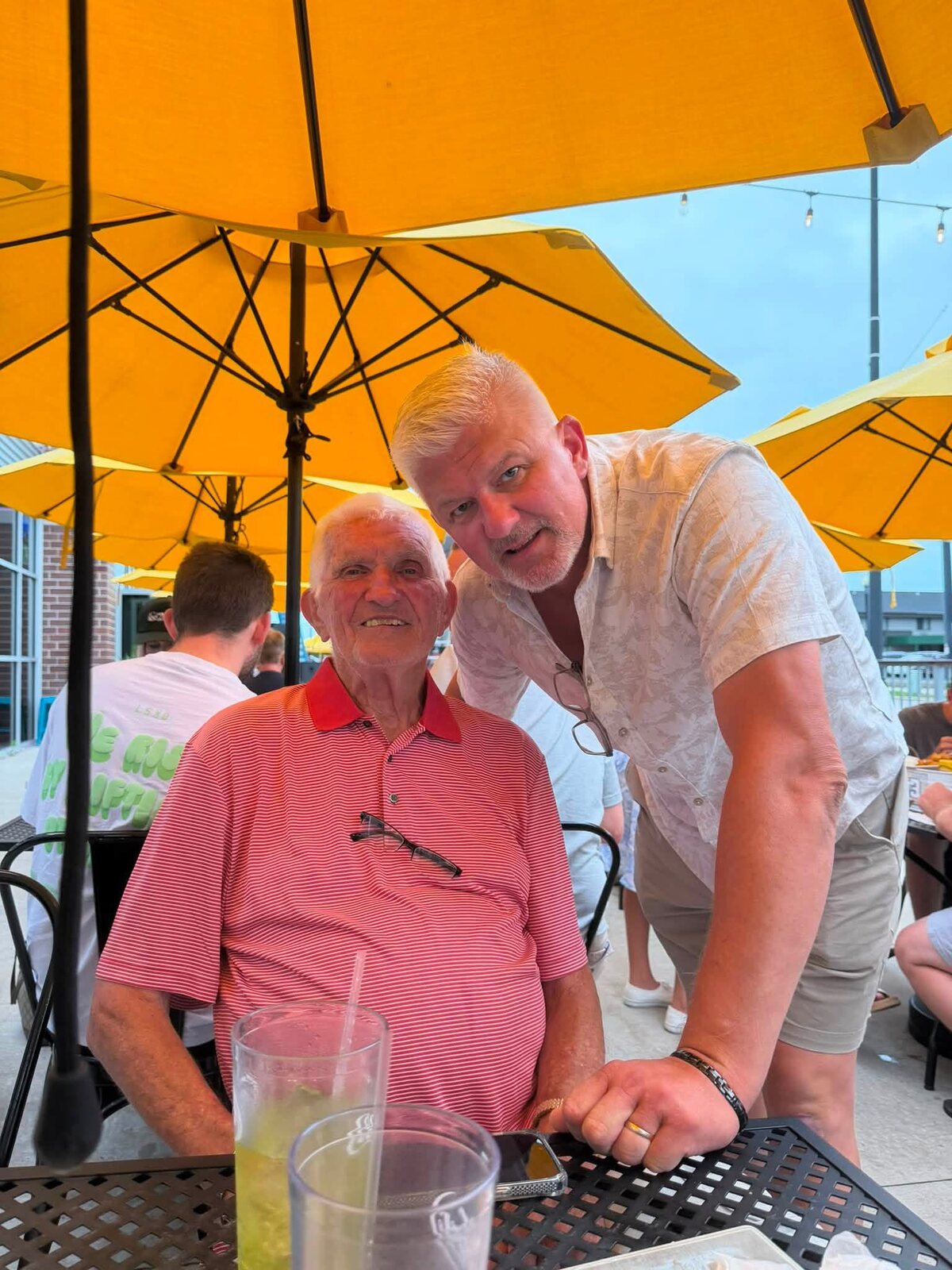 Lee Liljenquist seated outdoors with another family member during a gathering.