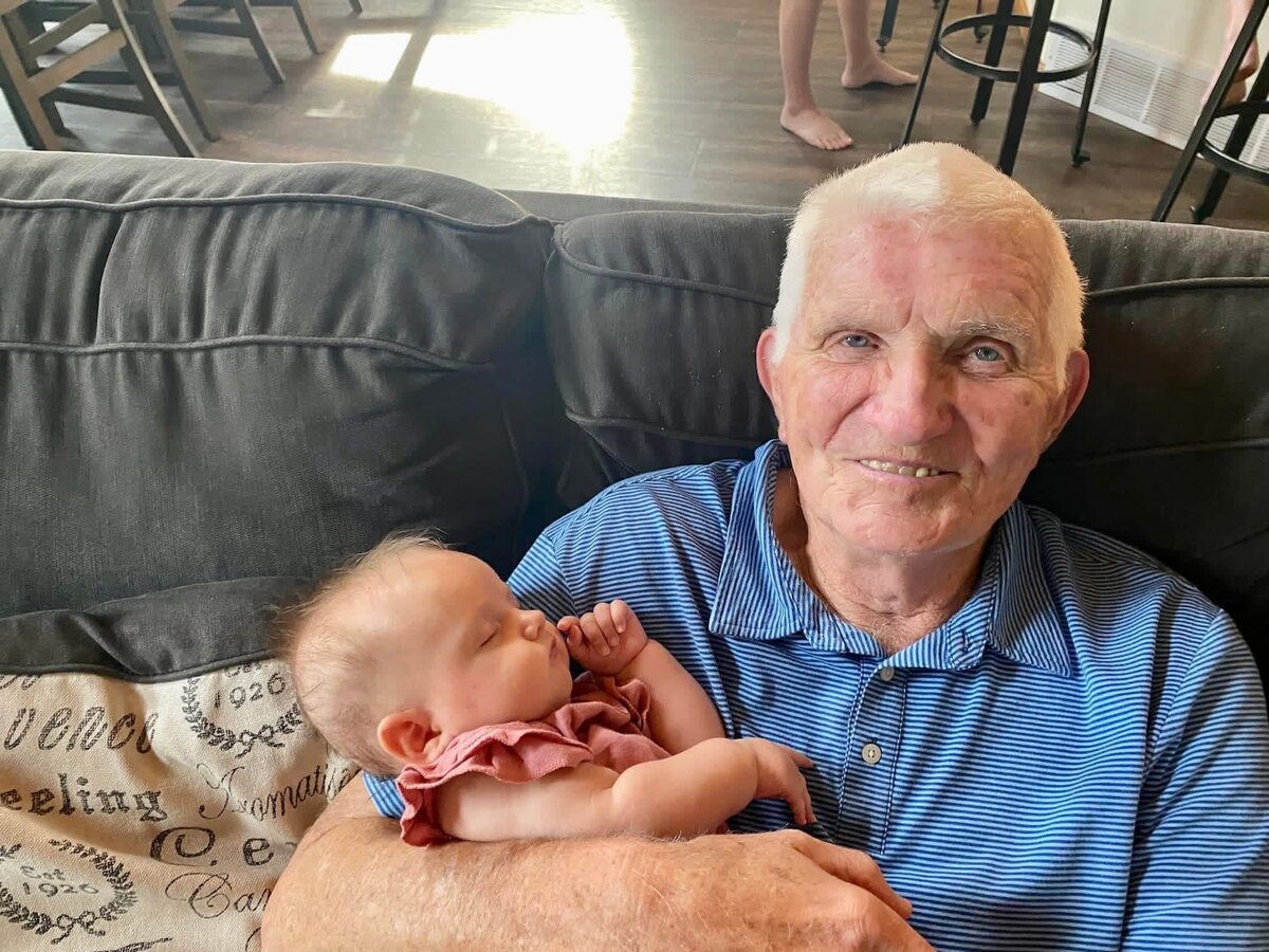 Lee Liljenquist holding a sleeping baby during a family gathering.