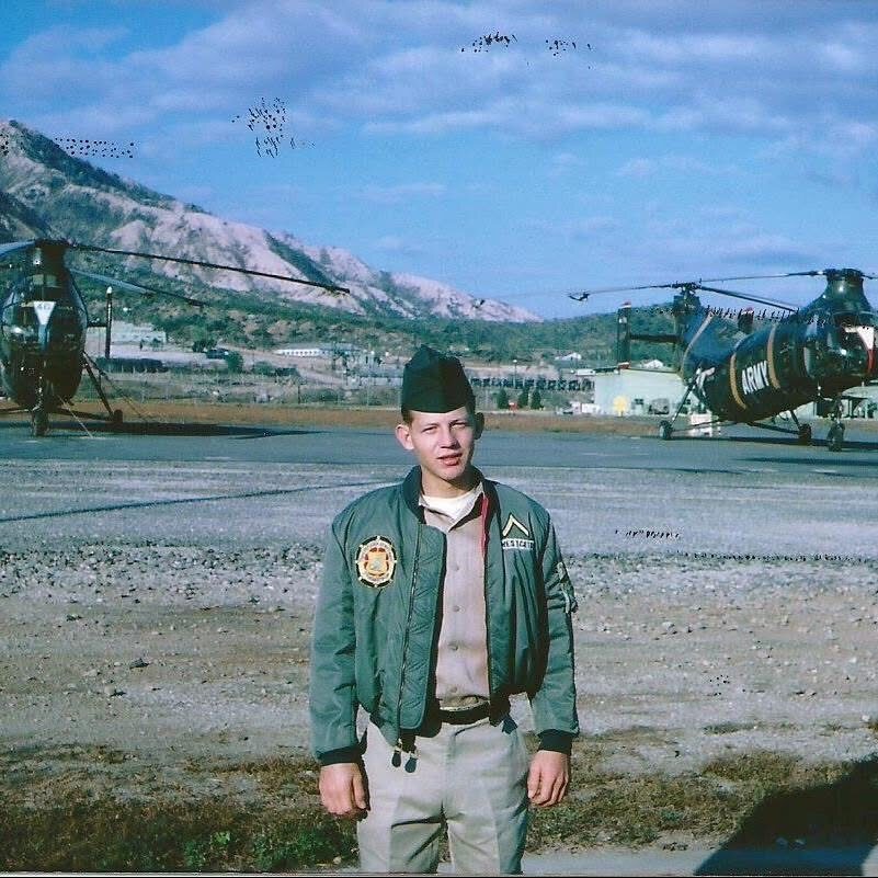 Thomas Emmett Westcott Jr. during his U.S. Army service, standing near military helicopters.