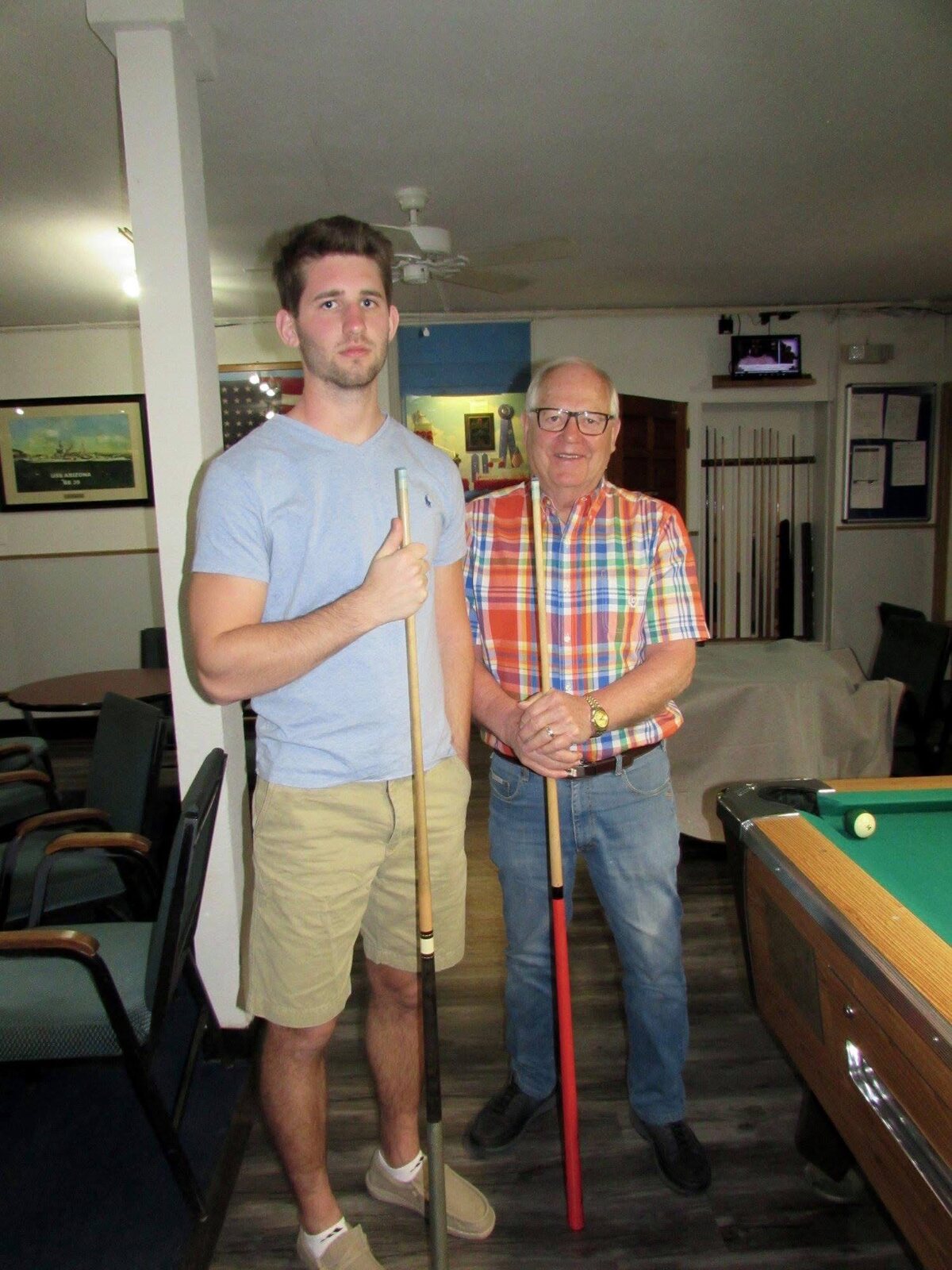 Josh Liljenquist with his grandfather Thomas Emmett Westcott Jr. holding pool cues.