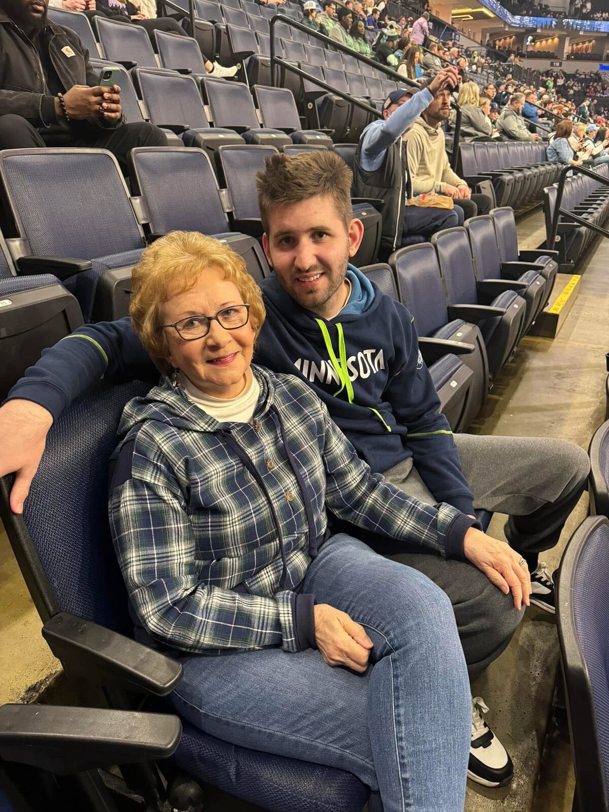Josh Liljenquist sitting with his maternal grandmother, Mary Ann Westcott, at a sporting event.