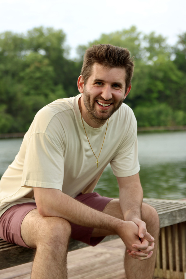 Close smiling portrait of Josh Liljenquist seated beside the water