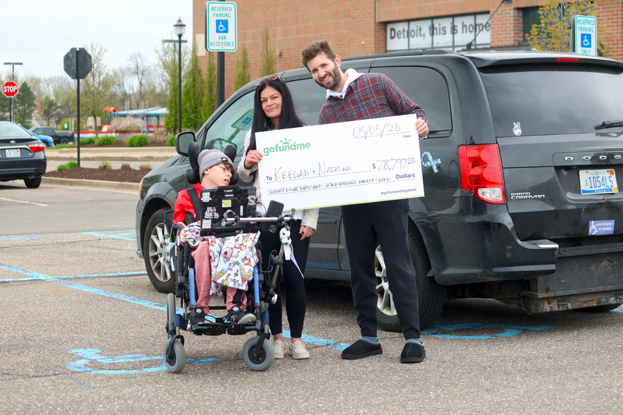 Josh Liljenquist with Natasha and Keegan holding a GoFundMe check displaying $78,797