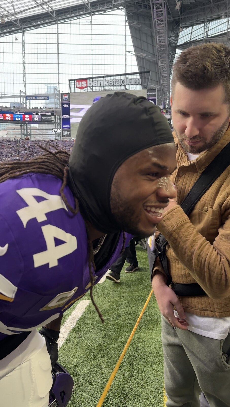 Josh Liljenquist with Minnesota Vikings player Josh Metellus during a field experience at U.S. Bank Stadium.