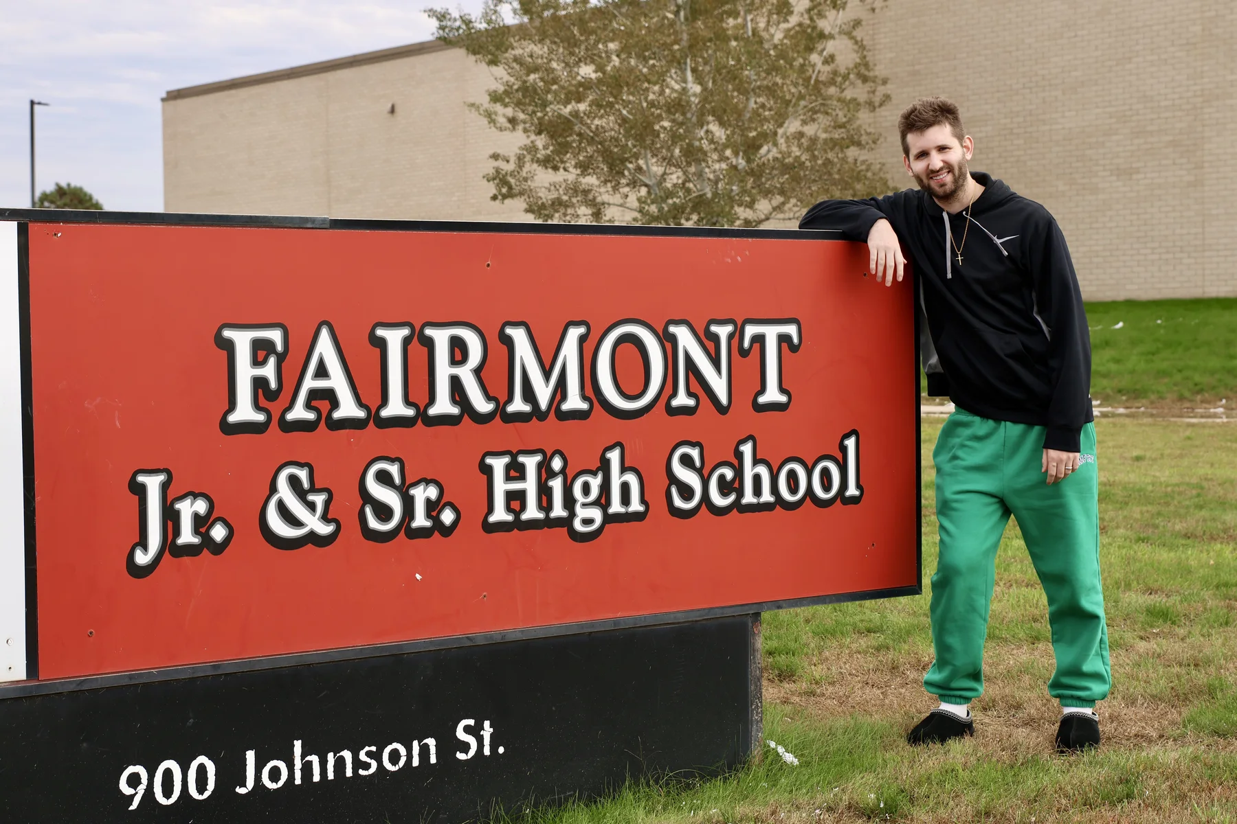 Josh Liljenquist beside the Fairmont Jr. & Sr. High School sign in Fairmont, Minnesota