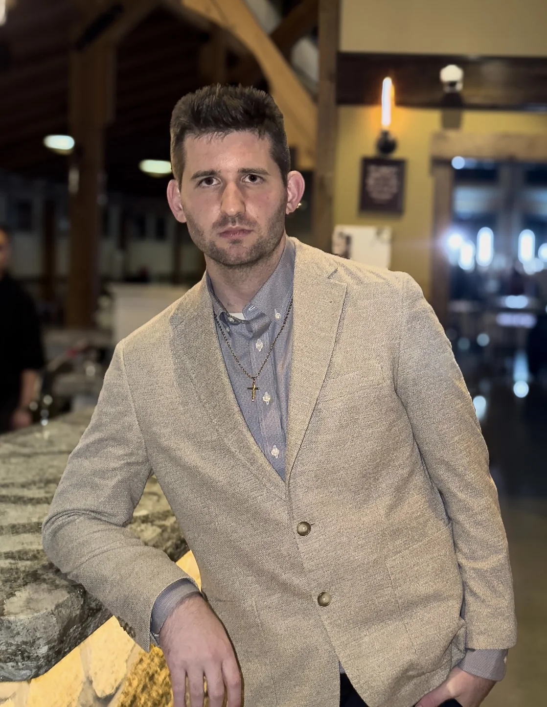 Josh Liljenquist standing in a light beige blazer and blue shirt at Chankaska Creek Ranch near Kasota, Minnesota.