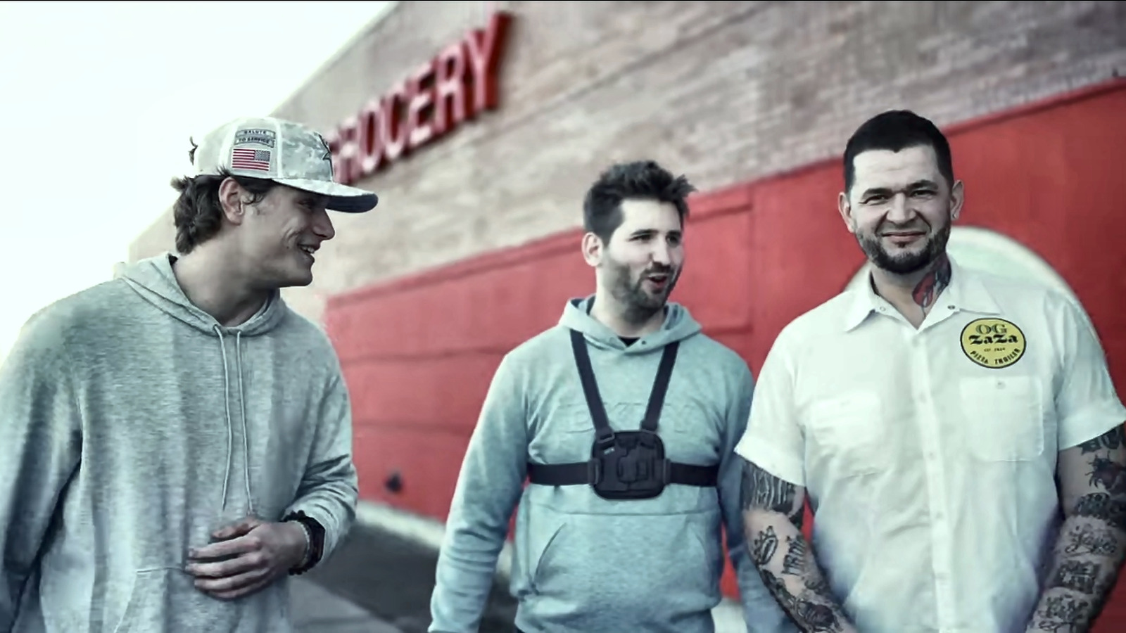 Josh Liljenquist standing with two collaborators outside a grocery store during a community supply project