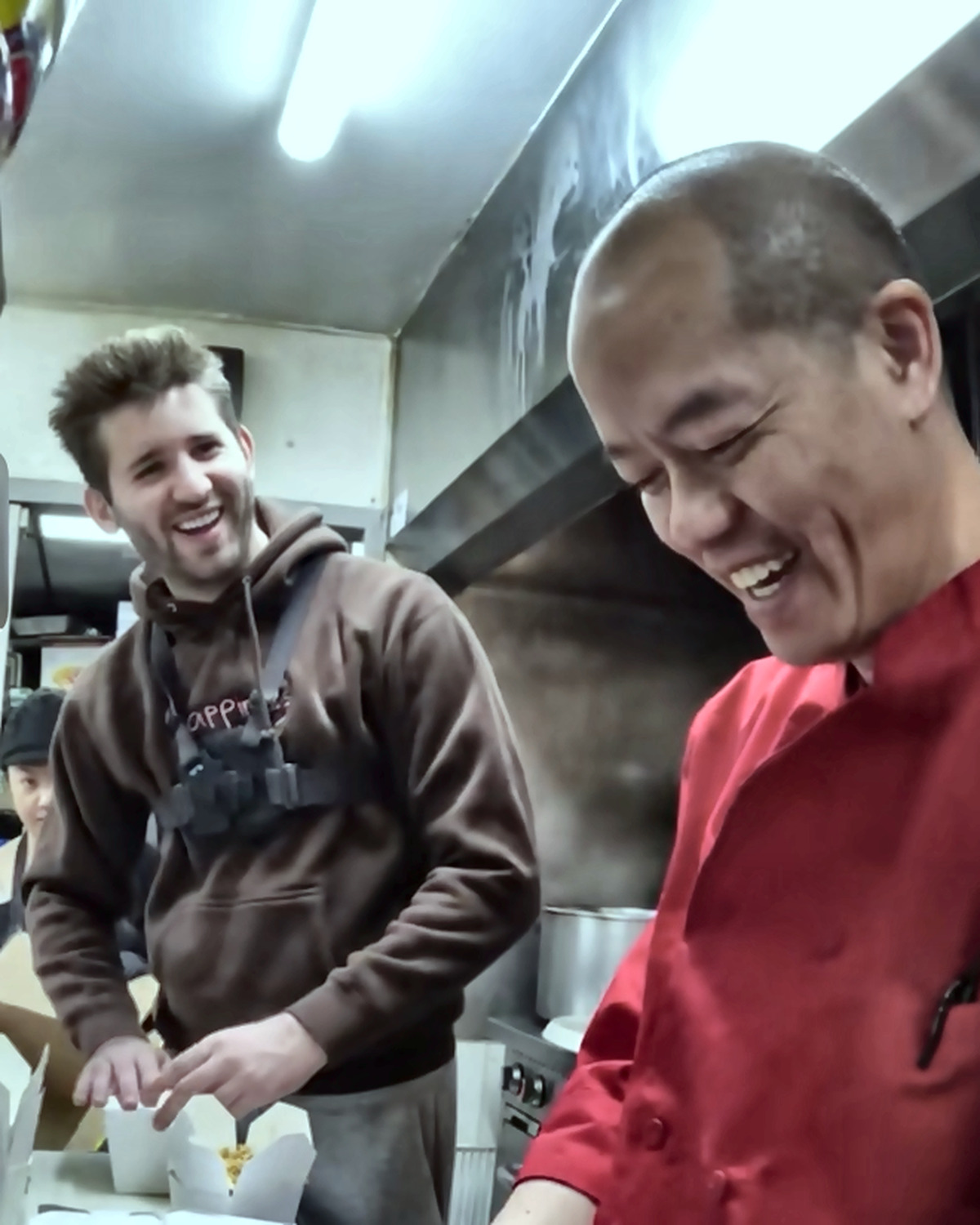 Josh Liljenquist and a chef packaging prepared meals in a commercial kitchen
