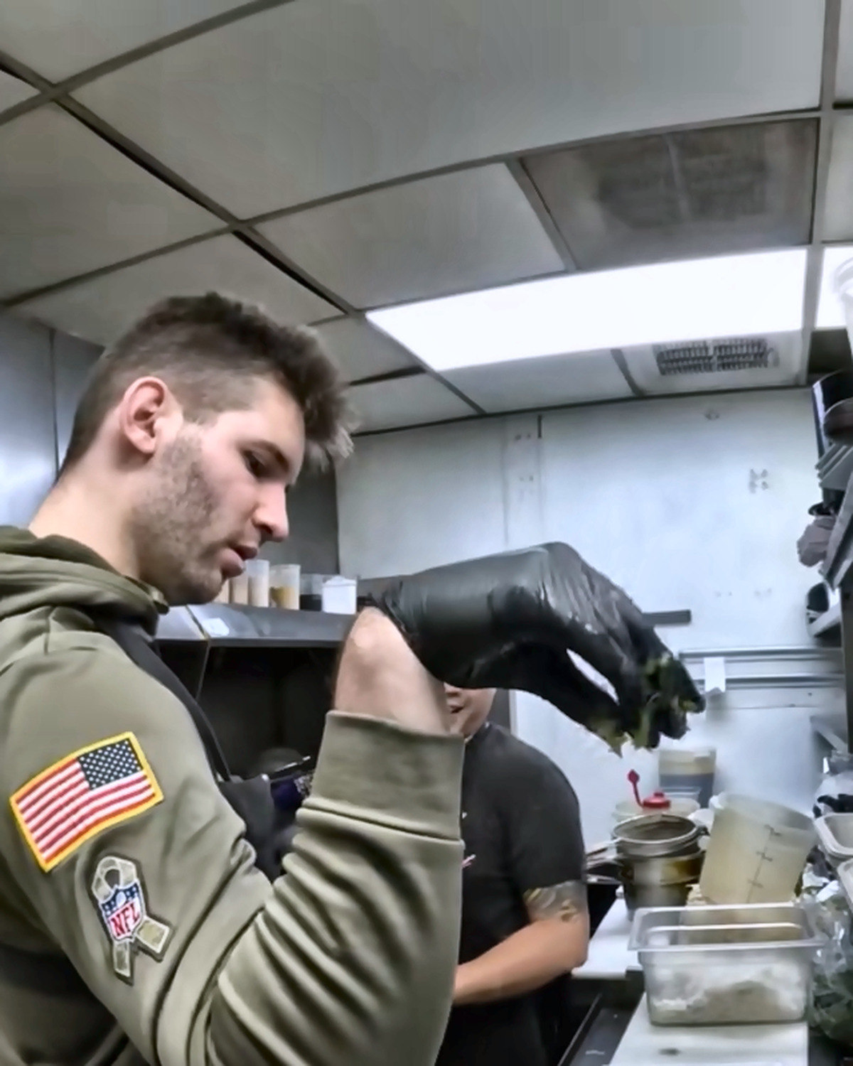 Josh Liljenquist adding ingredients to plated meals in a commercial kitchen
