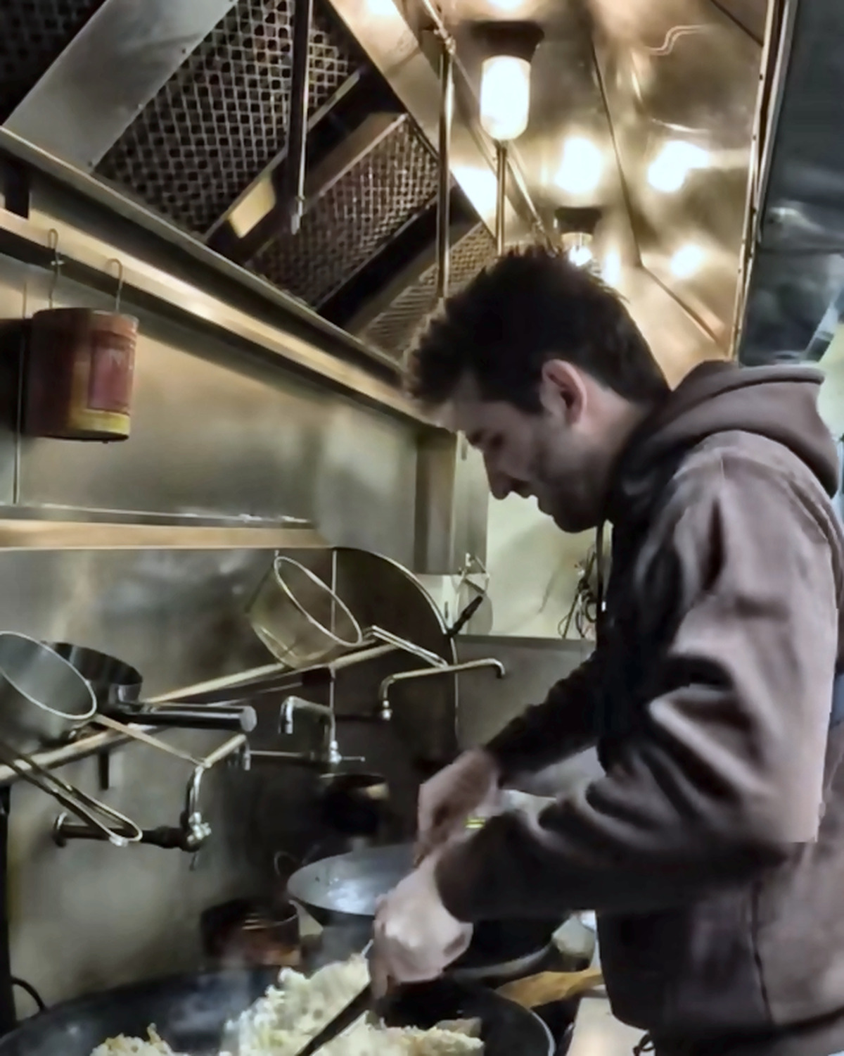 Josh Liljenquist cooking rice at a commercial stove during a community meal project