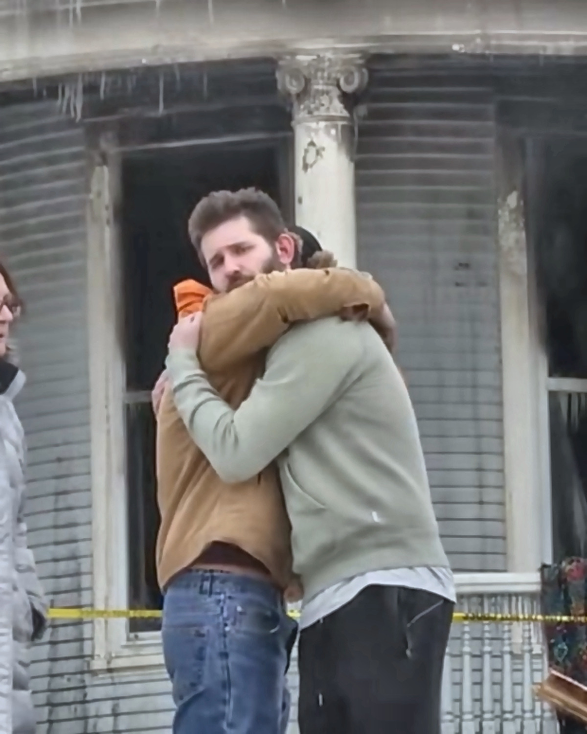 Josh Liljenquist embracing a man outside a fire-damaged home during a disaster-recovery assistance story