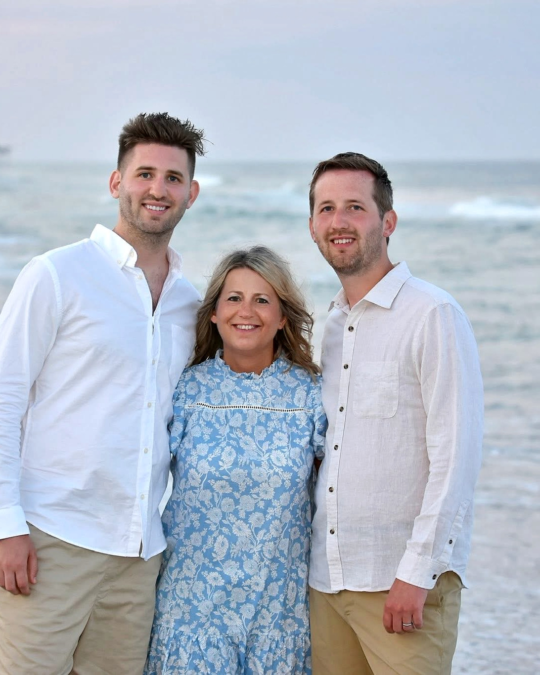 Josh Liljenquist with two family members in a beach portrait at sunset