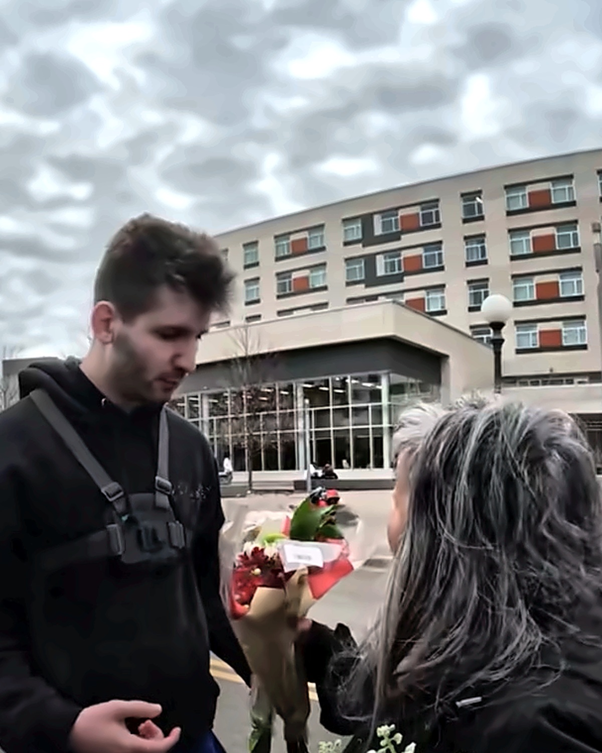 Josh Liljenquist speaking with a woman holding flower bouquets during a community kindness outreach