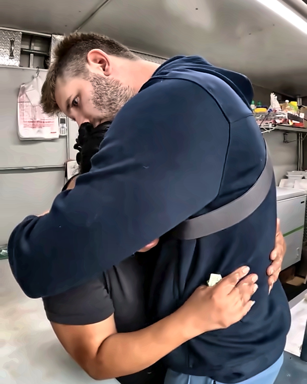 Josh Liljenquist embracing a community participant inside a food trailer after a meal-service project