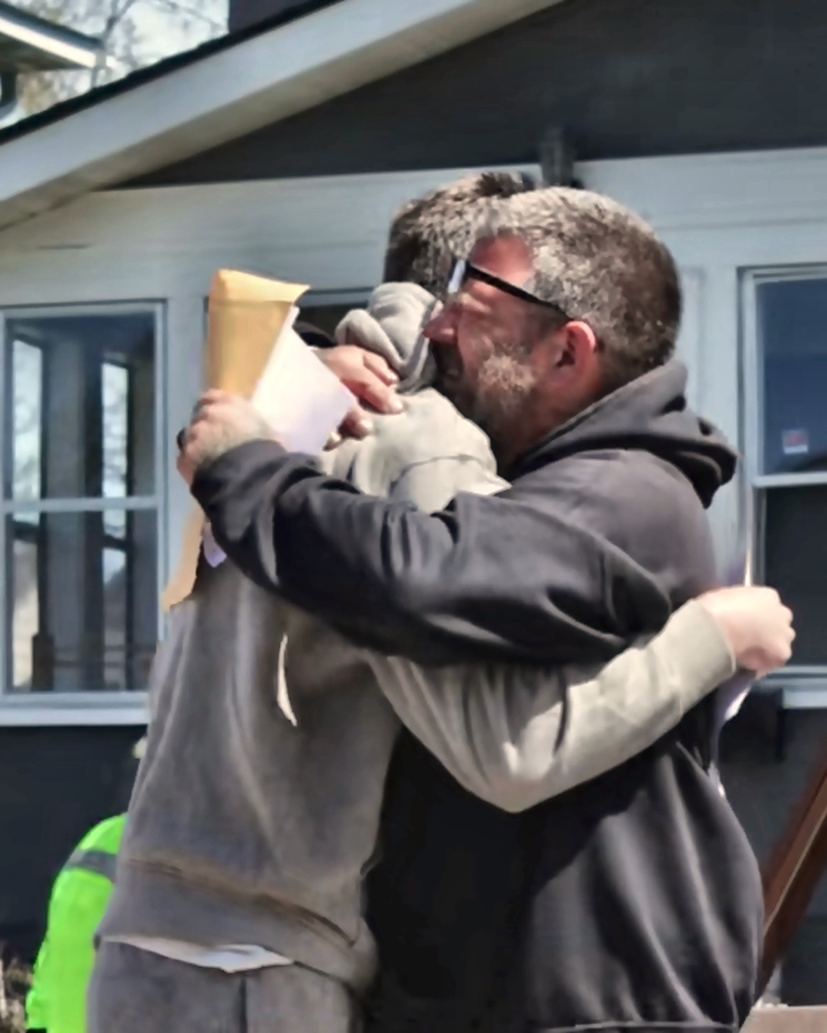 Josh Liljenquist embracing a man outside a home during a documented housing milestone