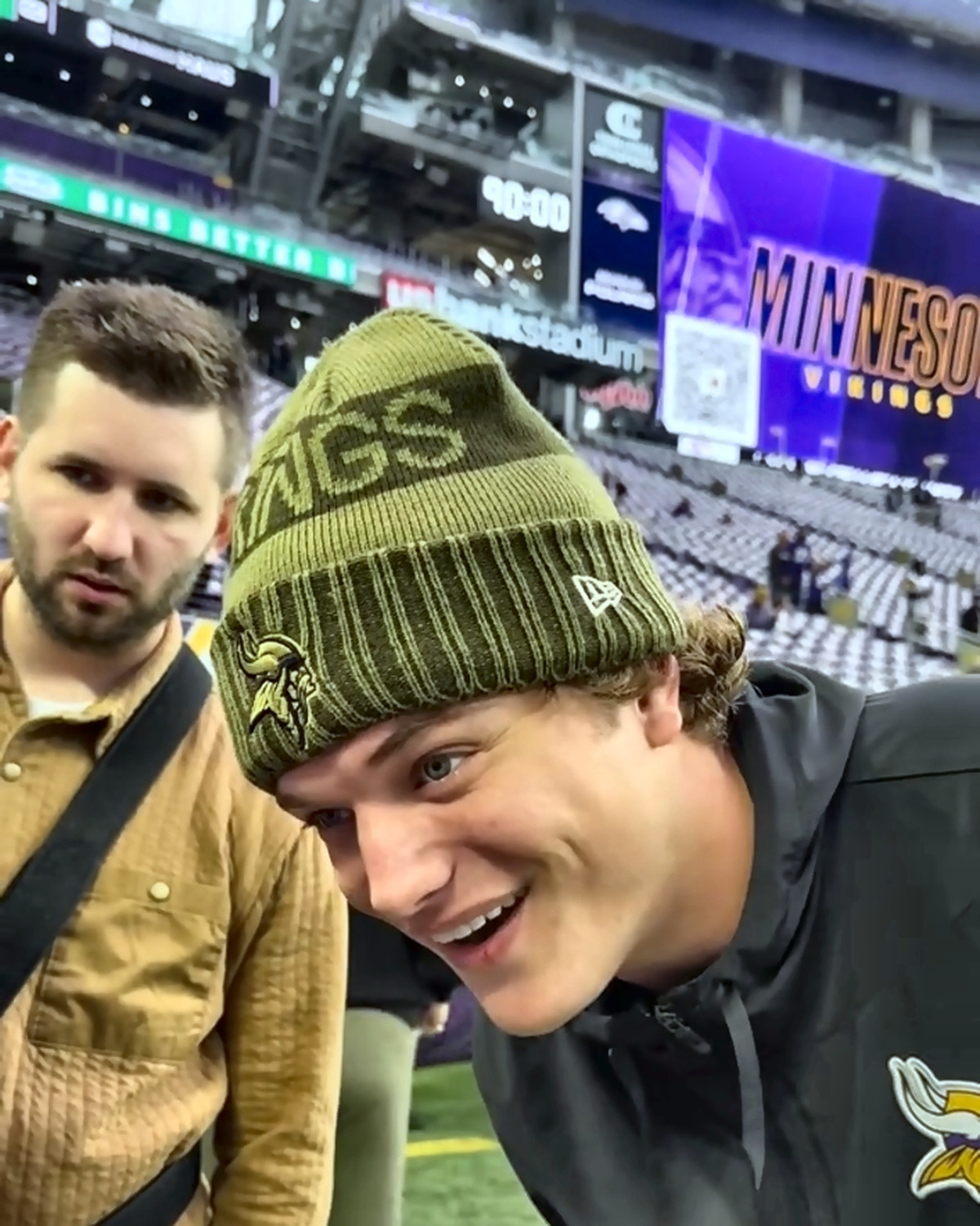 Josh Liljenquist standing with JJ McCarthy on the field at a Minnesota football event