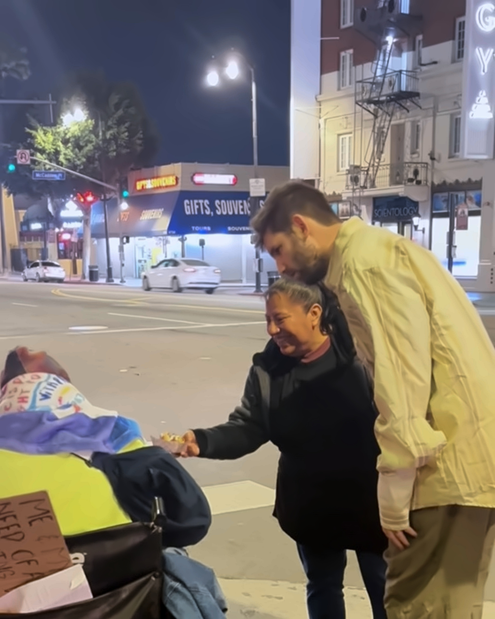 Josh Liljenquist and a team member speaking with a wheelchair user during a nighttime street-outreach interaction