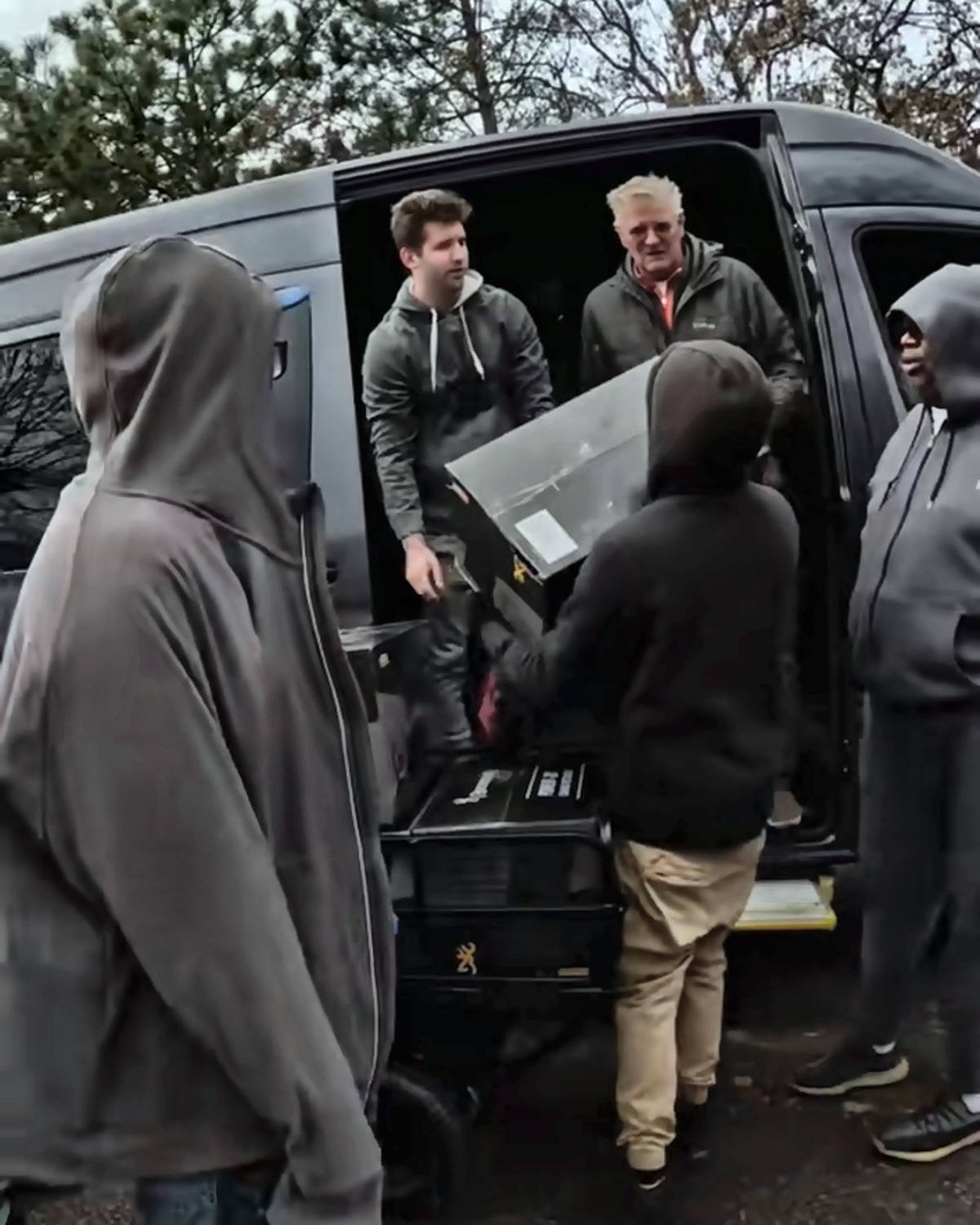 Josh Liljenquist and volunteers unloading boxed supplies from a van during a sleeping-bag distribution project
