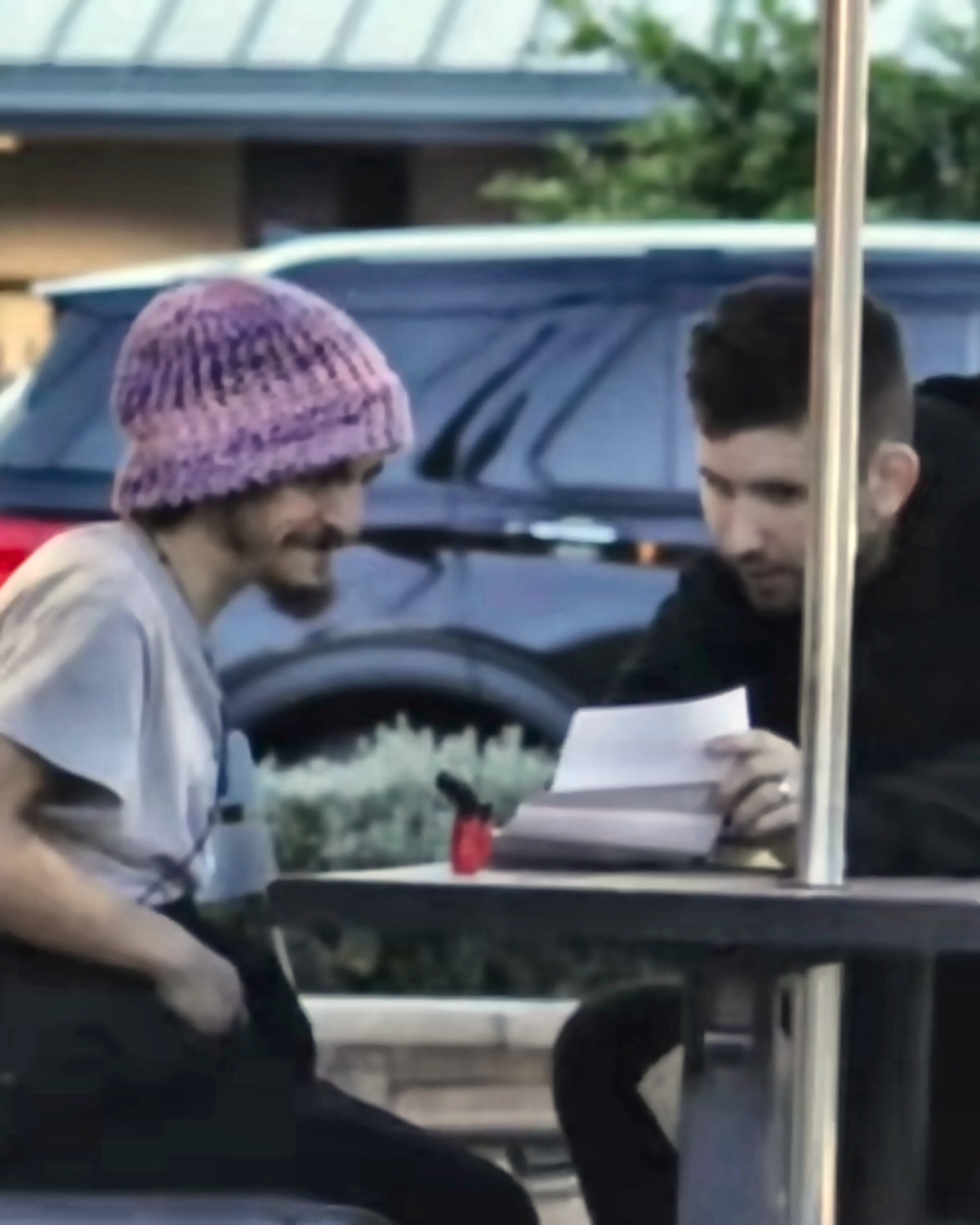 Josh Liljenquist reviewing a document with actor Tylor Chase at an outdoor table