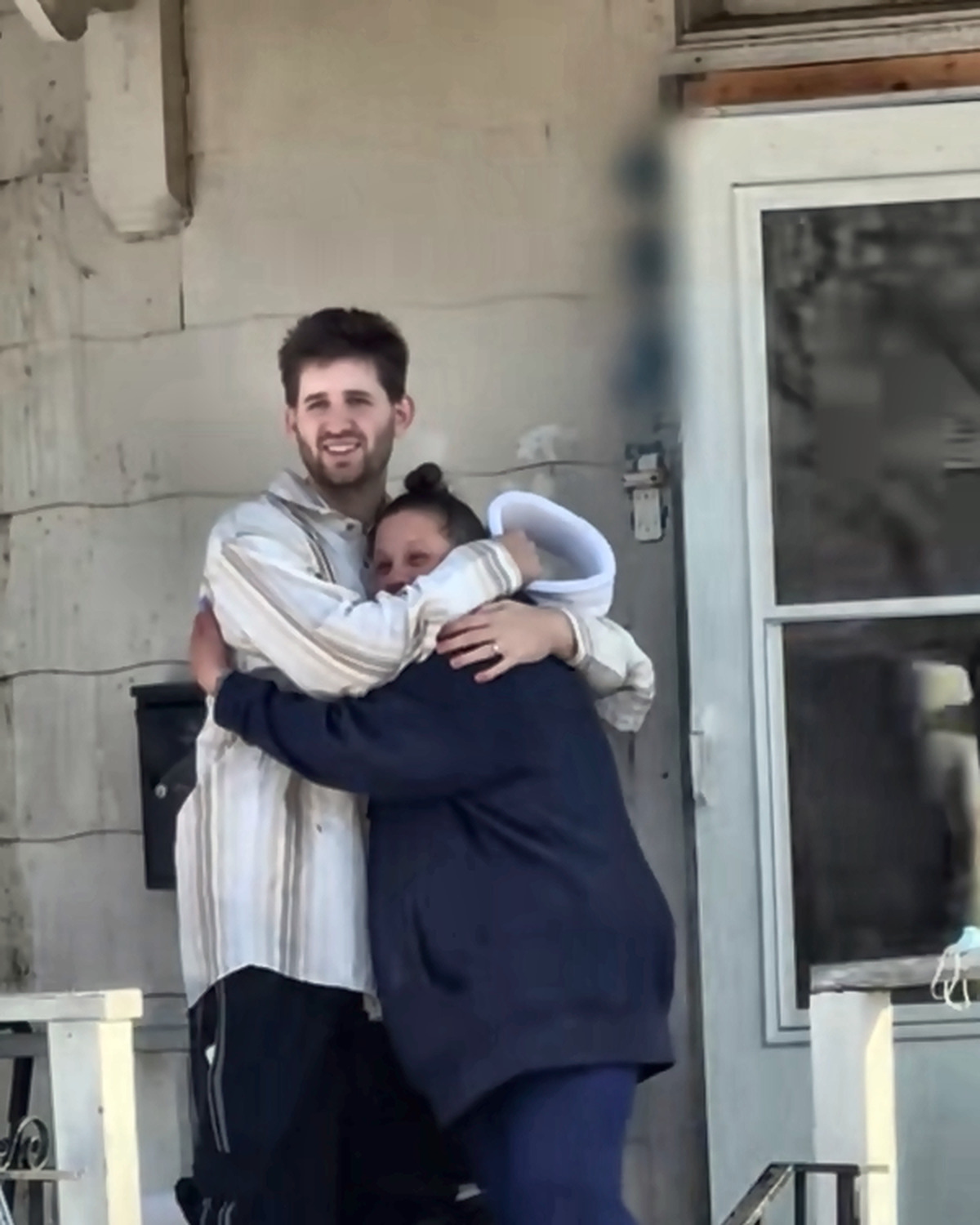 Josh Liljenquist embracing a woman on a snowy porch during a personal assistance story